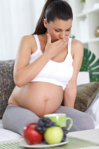 Pregnant woman with nausea sitting in living room